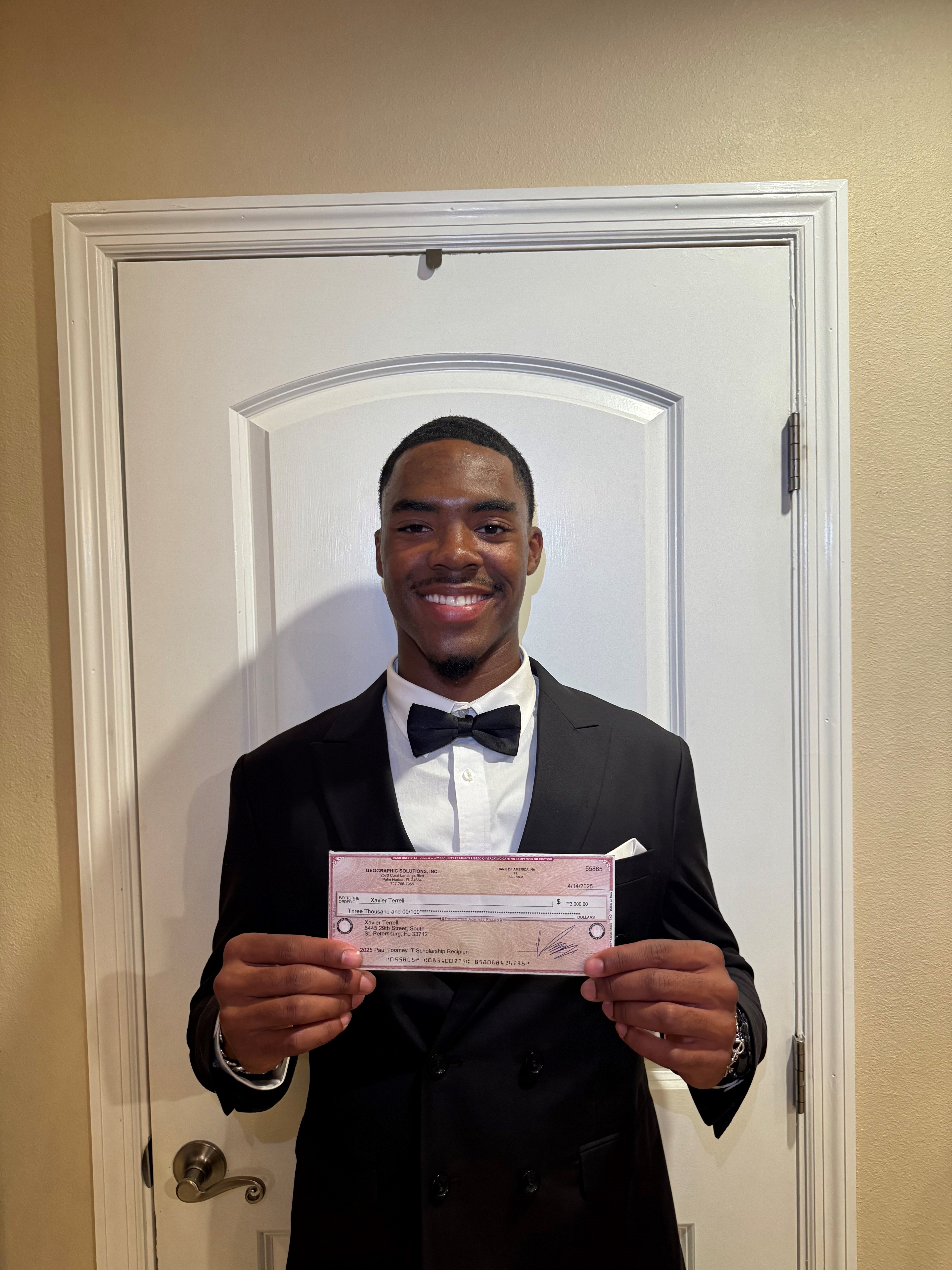 Xavier Terrell holding IT Scholarship Award check